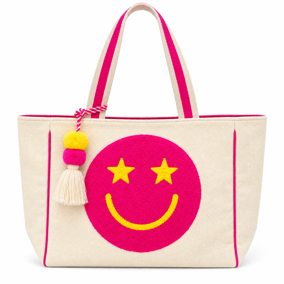 Pink Star Smiley Canvas Tote Bag front view showing natural canvas body with oversized hot pink chenille smiley face patch, yellow star eyes and smile, hot pink trim piping, pink-striped dual shoulder handles, and yellow and pink pom-pom tassel charm with cream fringe on white background
