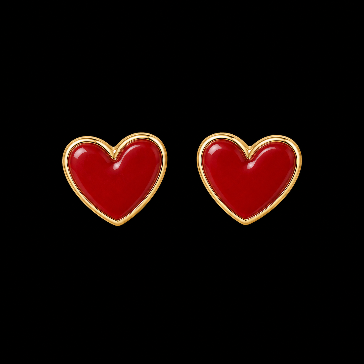 Red enamel heart stud earrings with polished gold-tone bezel trim shown as a pair front-facing on black background
