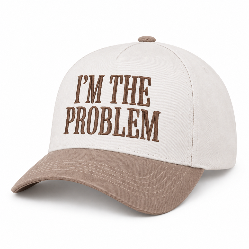 I'm the Problem Baseball Cap in Ash Mocha three-quarter angle view showing structured cream cotton crown with mocha raised serif block I'm the Problem embroidery and curved mocha bill on white background

