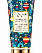 Close-up of the Frosted Coconut hand and body lotion label showing 180 mL and 6 fl oz surrounded by colorful holiday ornaments
