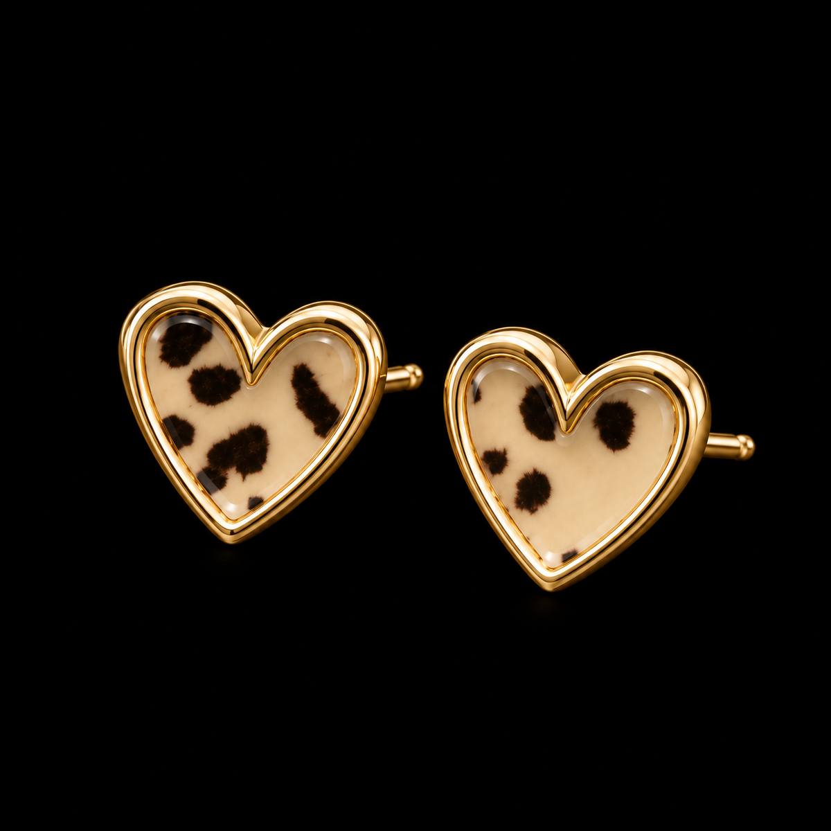 Leopard print heart stud earrings with gold-tone trim shown at an angle with gold post backings visible on black background
