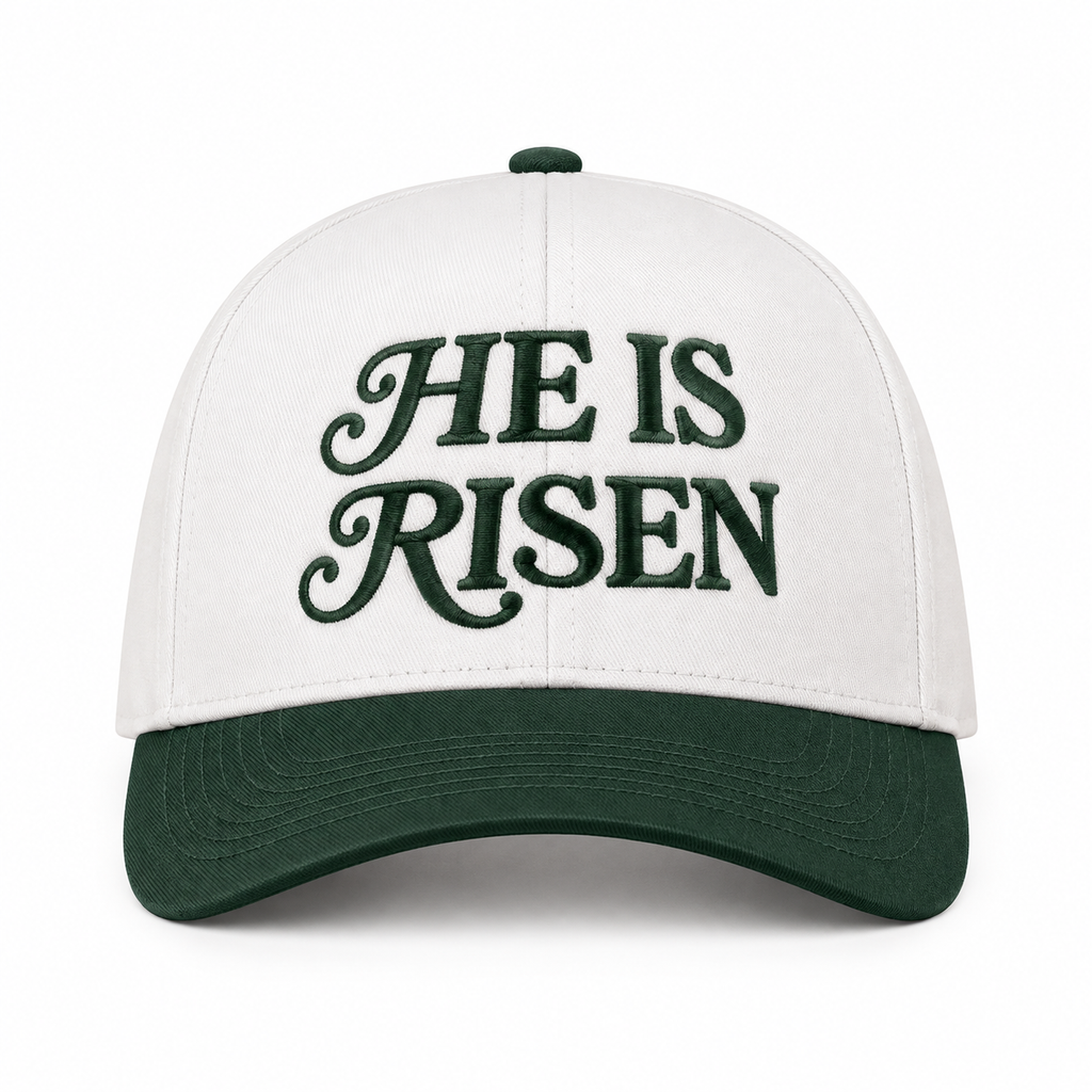 He Is Risen Baseball Cap in Dark Forest front view showing cream cotton crown with dark forest green decorative script He Is Risen embroidery, solid dark green bill, and dark green top button on white background
