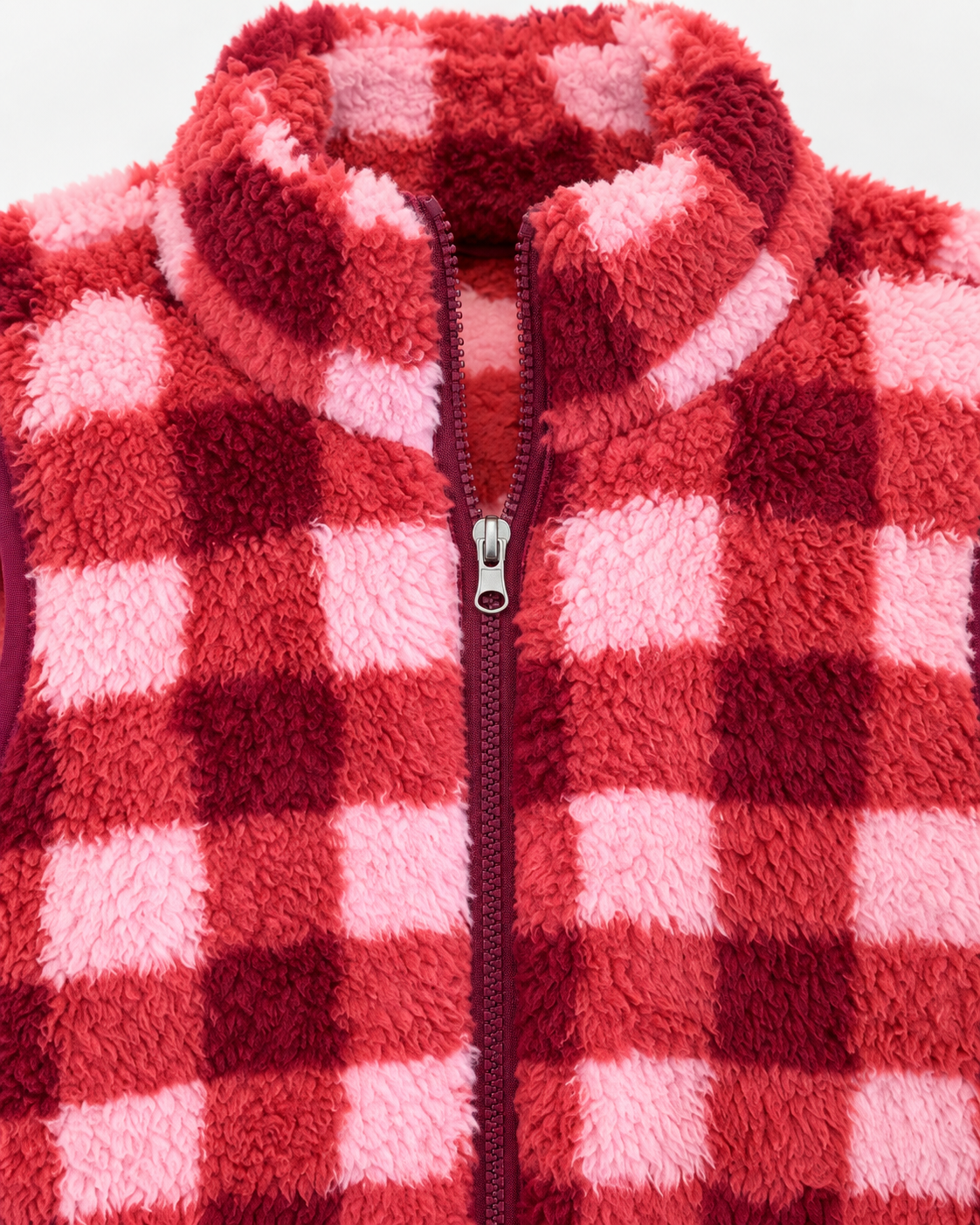 Close-up of the stand-up sherpa collar and burgundy front zipper on the pink, coral, and burgundy plaid vest
