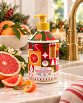 Molto Bella Sicilian Grapefruit hand soap beside a sink with sliced grapefruit, citrus fruit, Christmas greenery, and gold fixtures

