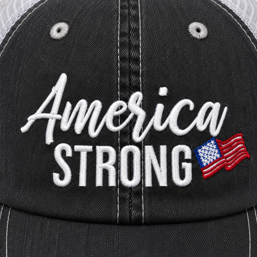 Close-up of white embroidered America Strong script text with a red, white, and blue American flag accent on a distressed black trucker hat.