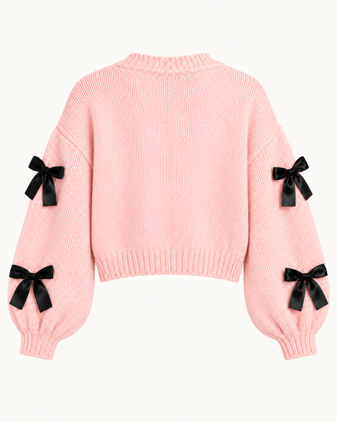 Back view of the pink cropped cardigan showing the plain knit back, black bows on the sleeves, and ribbed cuffs and hem
