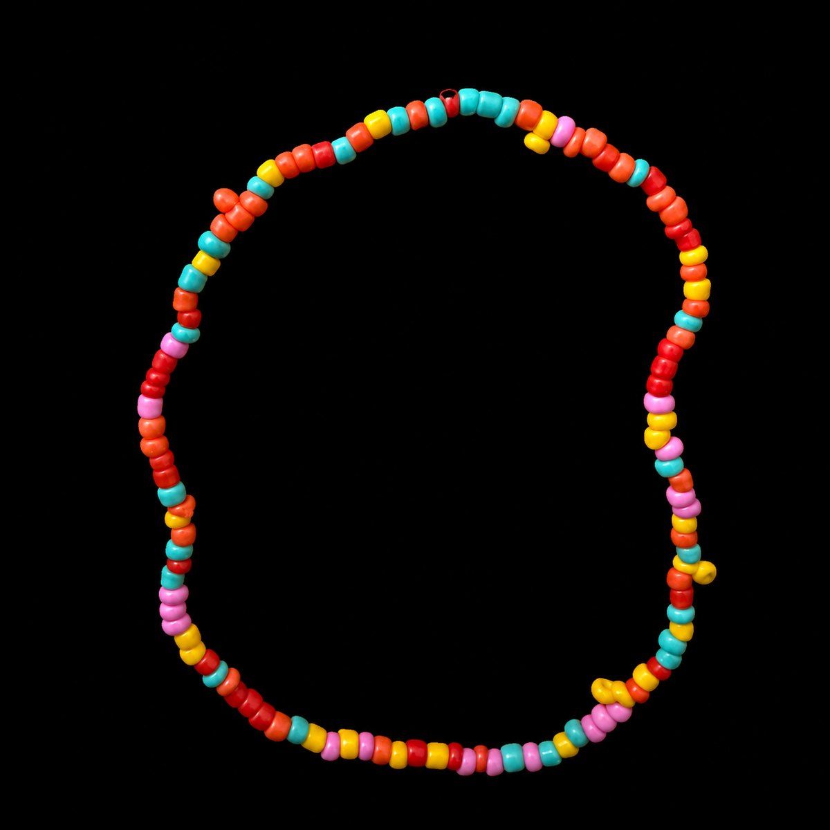 Colorful seed bead stretch bracelet with red, orange, yellow, turquoise, and pink beads displayed flat in a circle on black background
