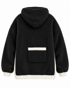 Back view of the black sherpa pullover hoodie showing the hood, back patch pocket with ivory top trim, and contrasting cuffs and waistband
