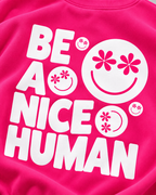 Close-up of the white Be a Nice Human back graphic with smiley faces featuring daisy-shaped eyes