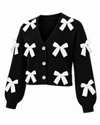 Black Satin Bow Knit Cardigan alternate front view showing black knit with white satin ribbon bows, deep V-neckline, pearl dome buttons, cropped length, and elasticized ribbed cuffs on white background
