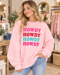 Model wearing the light pink Howdy crewneck sweatshirt with four colorful lettering rows, paired with jeans
