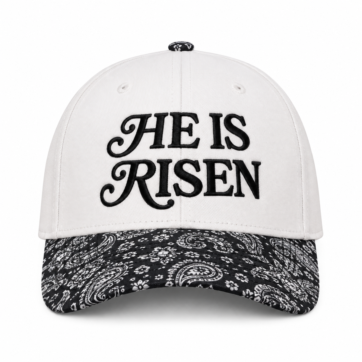 He Is Risen Baseball Cap in Black Paisley front view showing white cotton crown with black decorative script He Is Risen embroidery, black and white bandana paisley print bill, and paisley top button on white background

