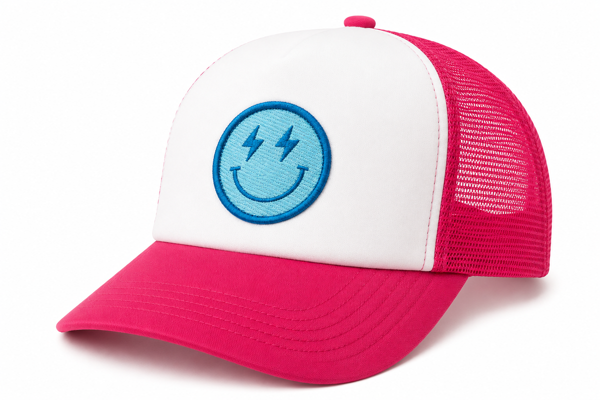 Electric Smiley Trucker Hat three-quarter angle view showing white front panel, hot pink bill, hot pink mesh back, and blue lightning-eye smiley face patch on white background
