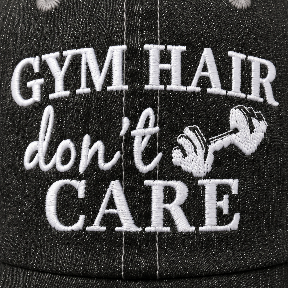 Close-up of white Gym Hair Don’t Care embroidery with dumbbell detail on black trucker hat.