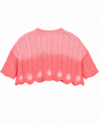 Back view of the pink cropped knit sweater showing its short sleeves and relaxed silhouette
