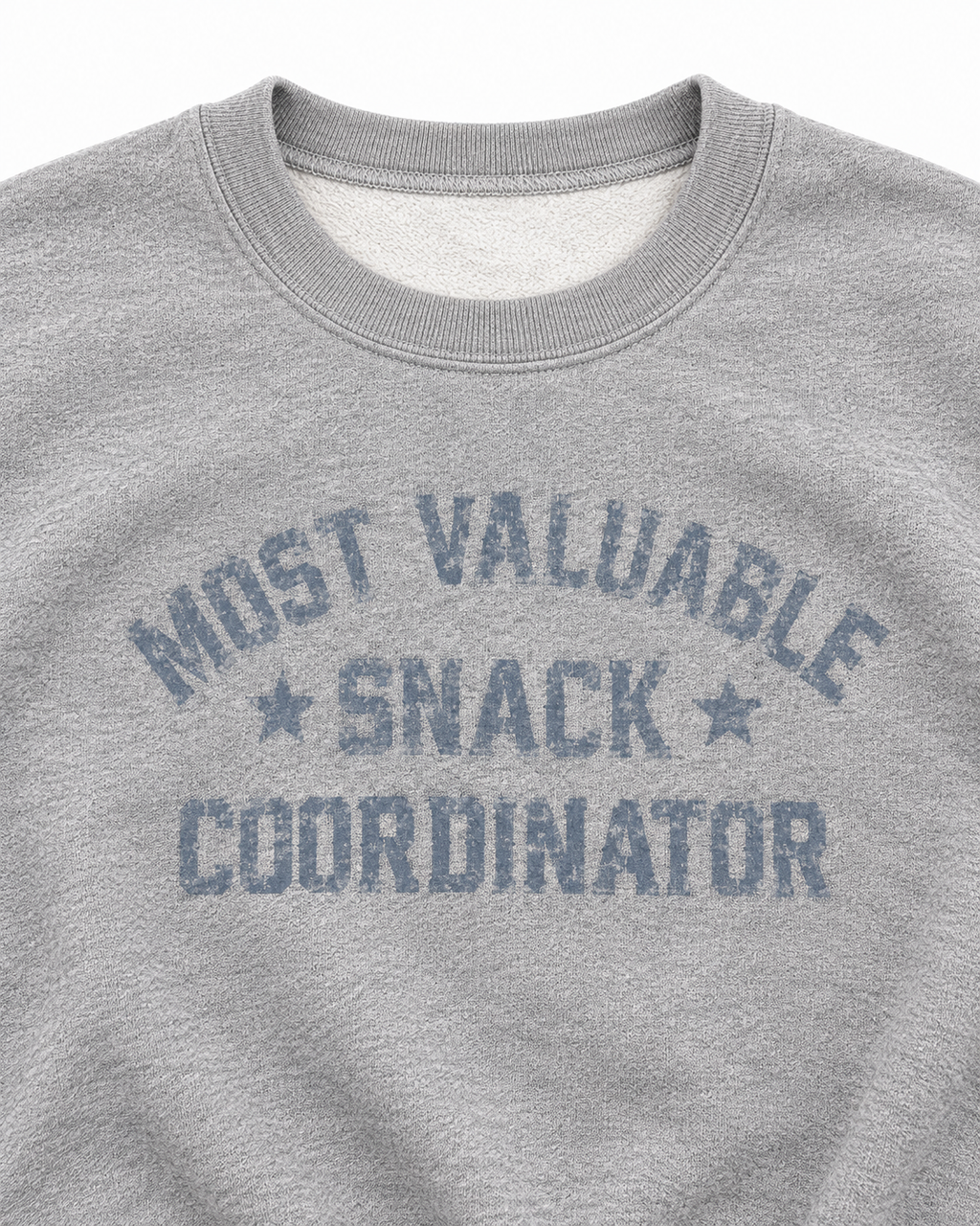 Close-up of distressed Most Valuable Snack Coordinator lettering, star accents, and the ribbed crew neckline
