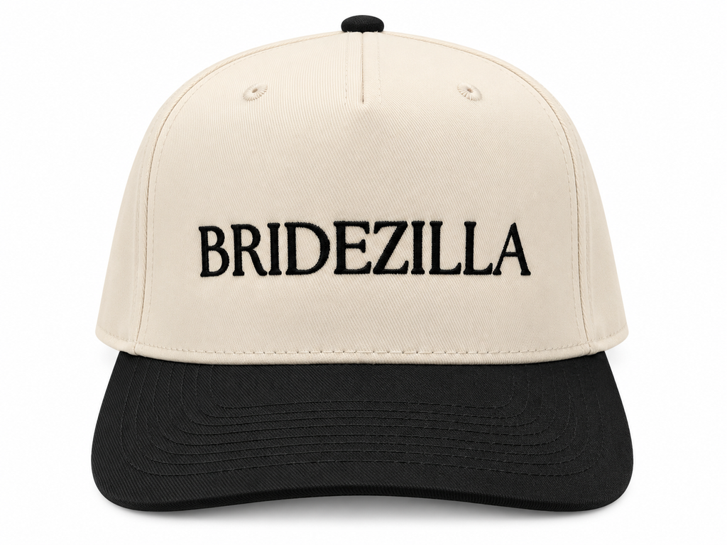 Bridezilla Baseball Cap front view with cream structured crown, black bill, and bold black embroidered BRIDEZILLA lettering on white background

