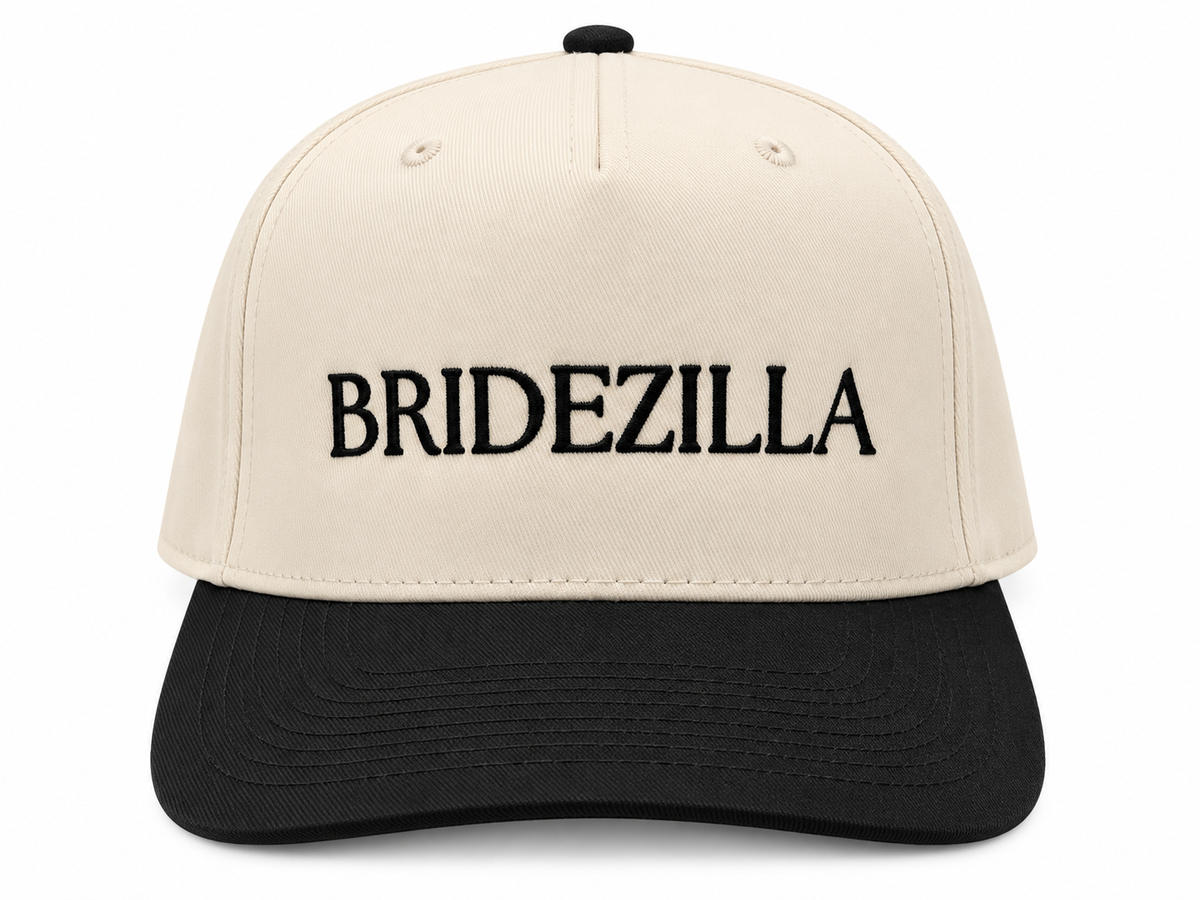 Bridezilla Baseball Cap front view with cream structured crown, black bill, and bold black embroidered BRIDEZILLA lettering on white background
