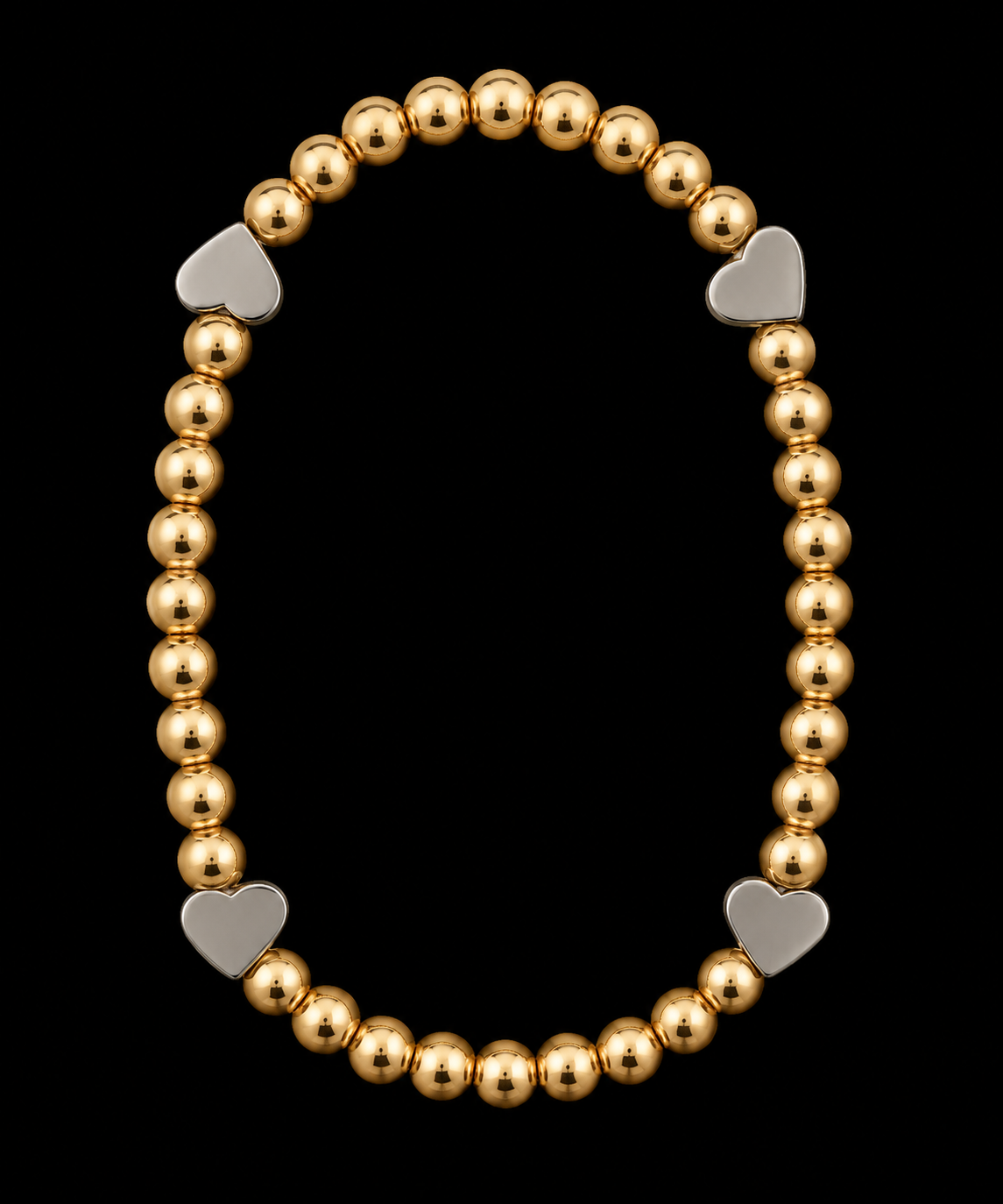 Gold-tone beaded stretch bracelet with four silver-tone heart accents displayed flat on black background
