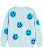 Back view of the light blue knit happy face sweater with turquoise smileys across the back and sleeves and ribbed cuffs and hem
