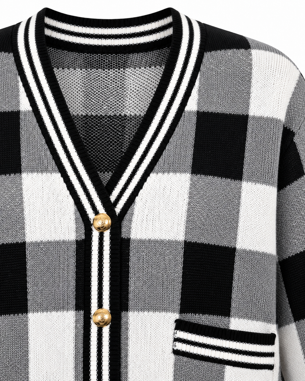Close-up of Black and White Plaid Gold Button Knit Cardigan showing deep V-neckline with black and white striped knit trim, antique gold dome buttons along placket, and striped patch pocket trim on black and white plaid knit on white background
