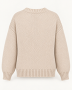 Back view of the tan knit sweater showing the plain back, dropped shoulders, long sleeves, and ribbed neckline, cuffs, and hem
