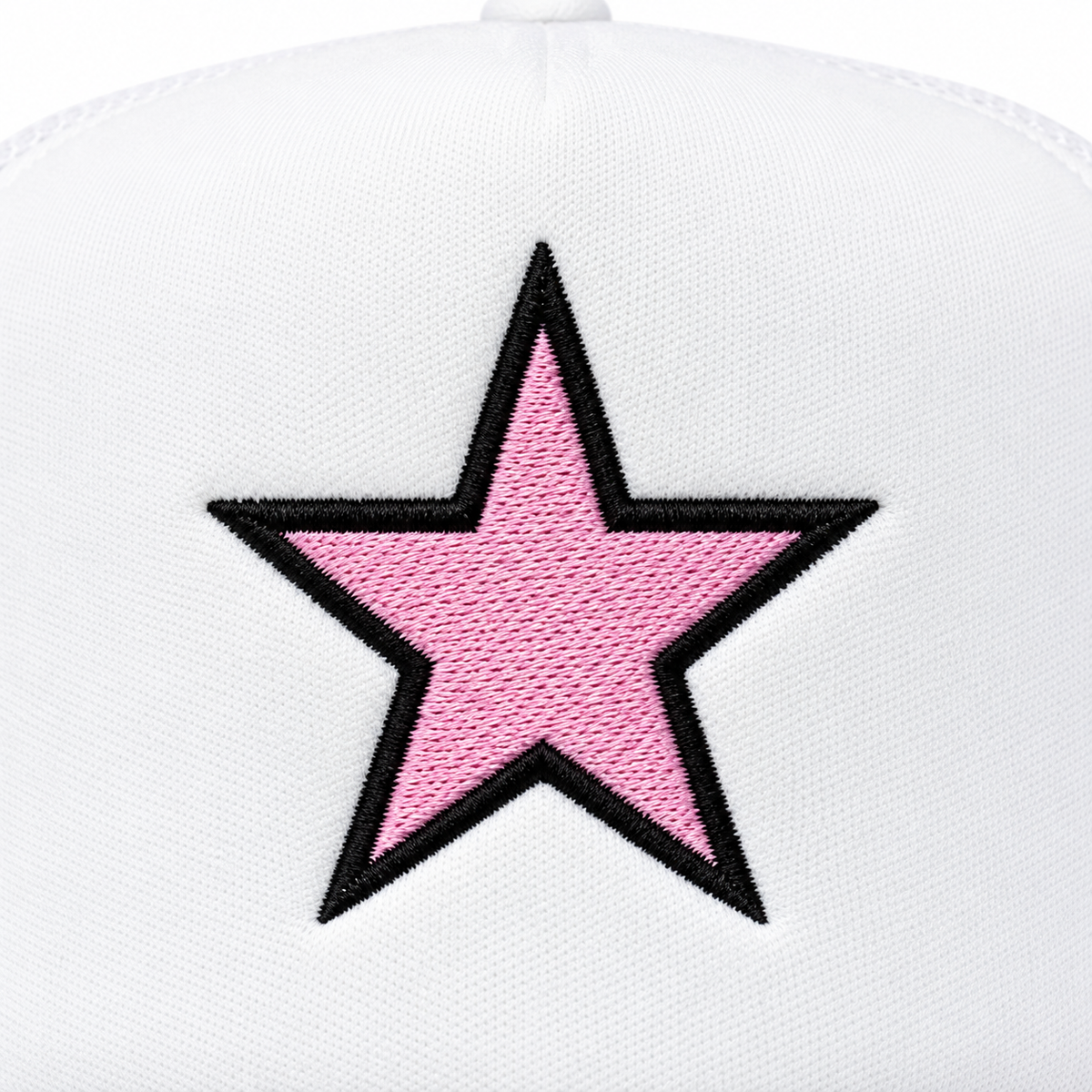 Close-up of large pink embroidered star with bold black outline on white structured trucker hat front panel
