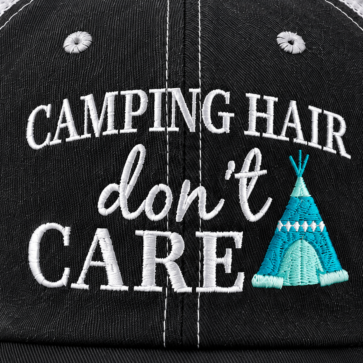 Camping Hair Don’t Care trucker hat close-up showing white embroidered lettering and teal teepee design on black fabric.