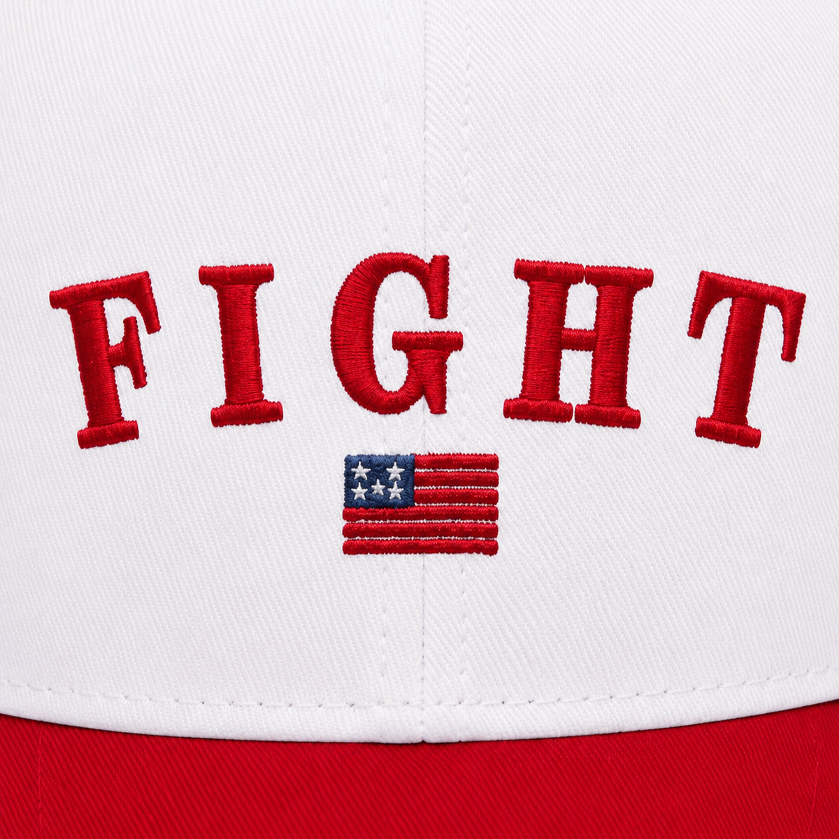 Close-up of bold red collegiate arched "FIGHT" embroidery with a detailed American flag emblem below on a white baseball cap front panel.

