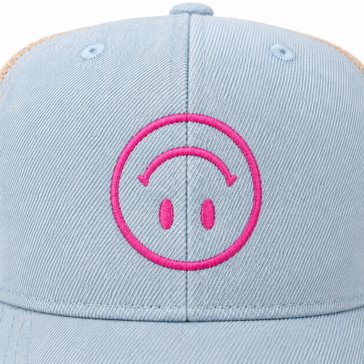 Close-up of hot pink embroidered upside-down smiley face on light blue distressed trucker hat
