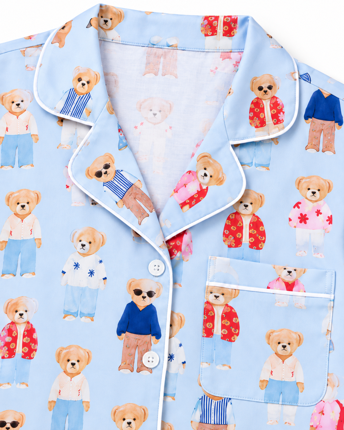 Teddy Bear Pajama Short Set shorts close-up flat lay showing light blue elastic waistband and all-over illustrated fashion teddy bear print in blue, red, and pink with white contrast piping along the cuffed hem on white background
