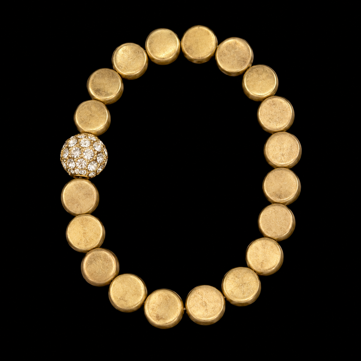 Gold coin bead stretch bracelet with single pavé crystal ball accent displayed flat in a circle on black background
