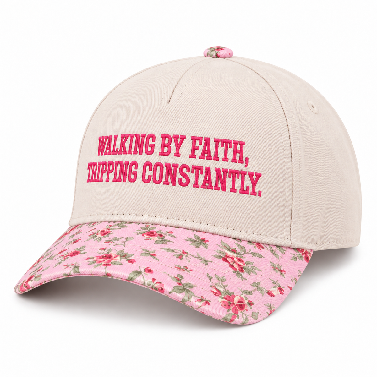 Walking By Faith Tripping Constantly Baseball Cap in Floral three-quarter angle view showing structured cream cotton crown with hot pink embroidered lettering, pink floral bill with red rose print, and pink floral top button on white background
