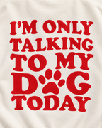 Close-up of the red I'm Only Talking to My Dog Today back graphic with a paw print replacing the O in DOG on cream fabric
