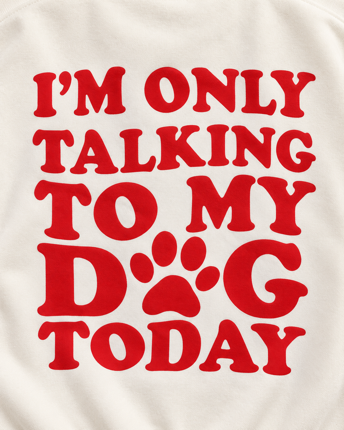 Close-up of the red I'm Only Talking to My Dog Today back graphic with a paw print replacing the O in DOG on cream fabric

