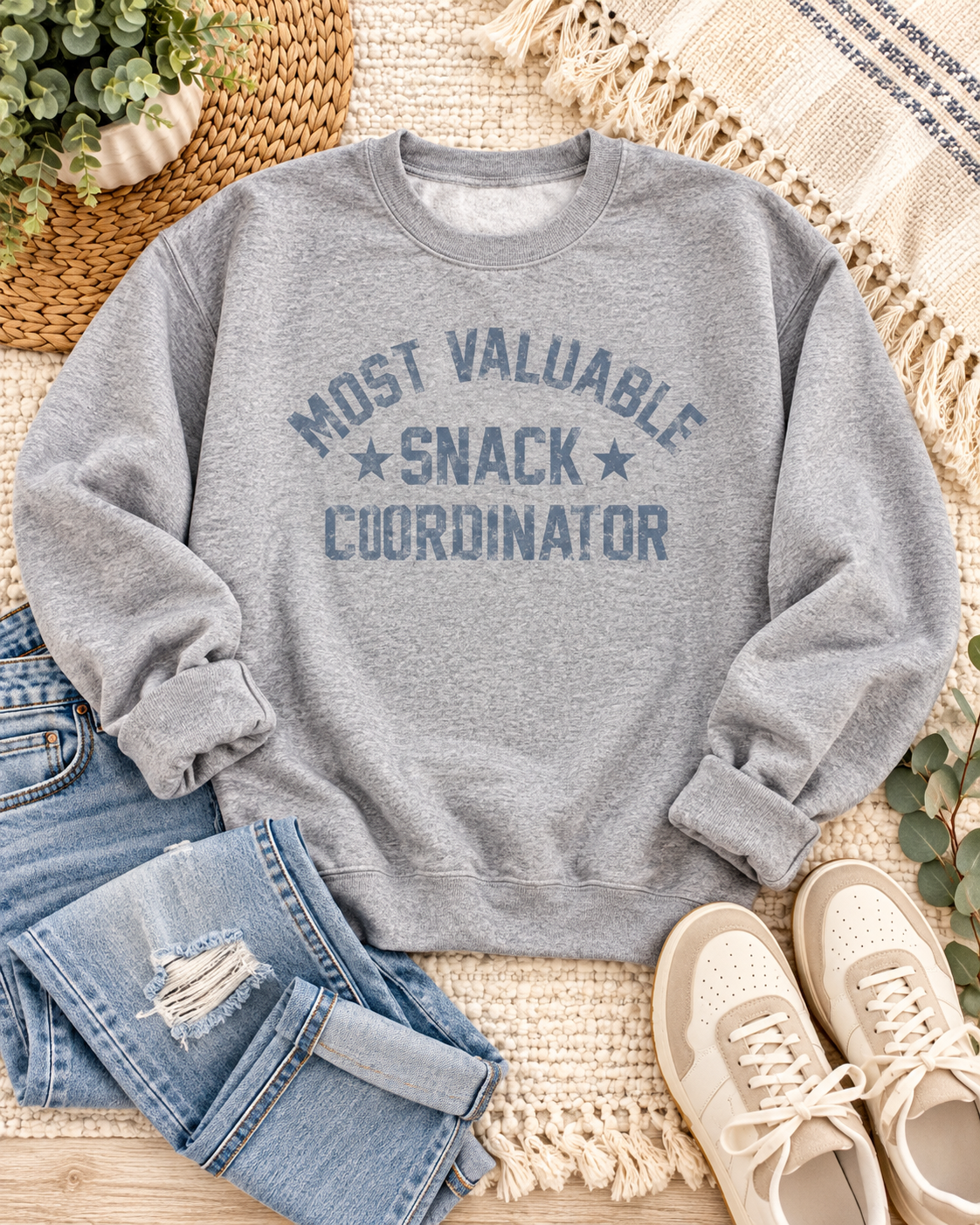 Heather gray Snack Coordinator sweatshirt styled with blue jeans, cream and tan sneakers, greenery, and neutral textured textiles
