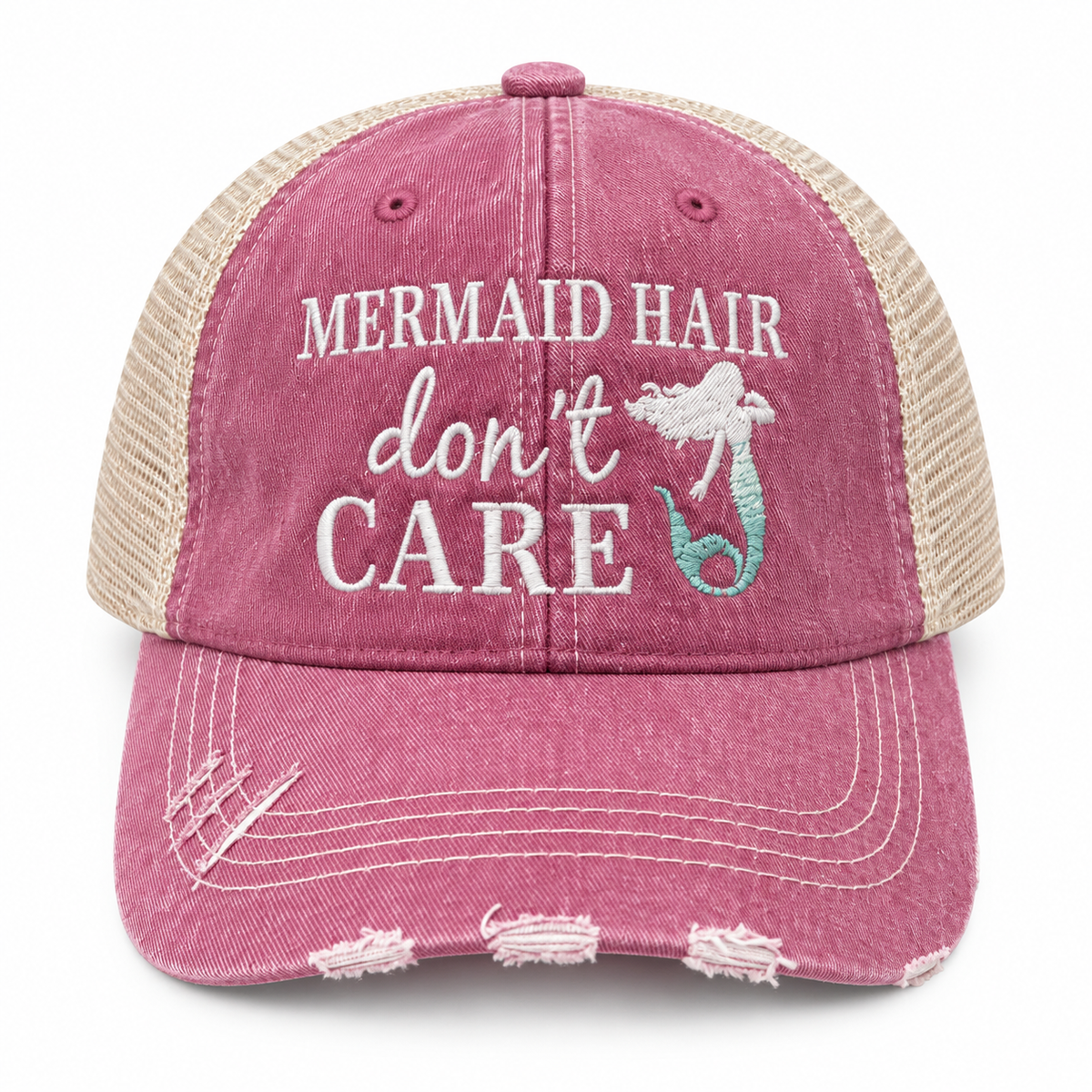 Mermaid Hair Don't Care Trucker Hat front view with washed pink distressed structured front, tan mesh back, and white embroidered Mermaid Hair Don't Care lettering with teal mermaid tail accent on white background
