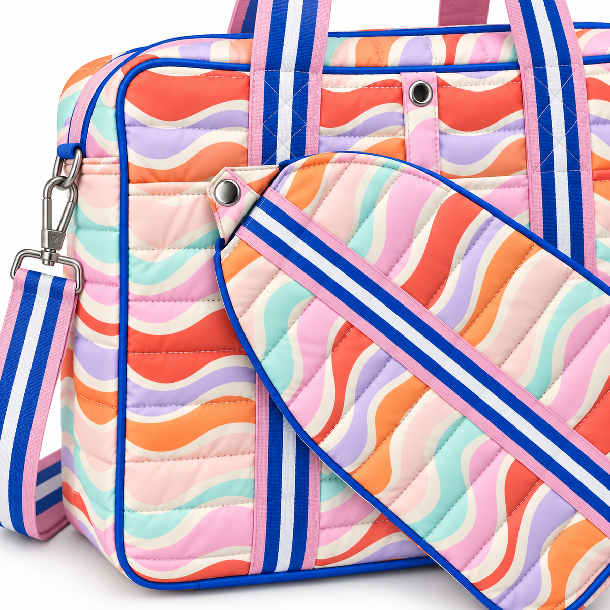 Close-up of Retro Wave Pickleball Bag showing quilted channel stitching on multicolor retro wave print polyester with royal blue trim, silver snap paddle holder attachment point, removable quilted paddle holder detail, and blue and white stripe crossbody strap with silver lobster clasp
