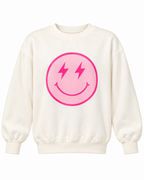 Front view of the cream sweatshirt with a light pink smiley face, hot pink lightning-bolt eyes, and a hot pink border
