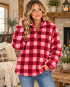 Model wearing the pink and burgundy plaid sherpa quarter-zip pullover with a stand collar and jeans
