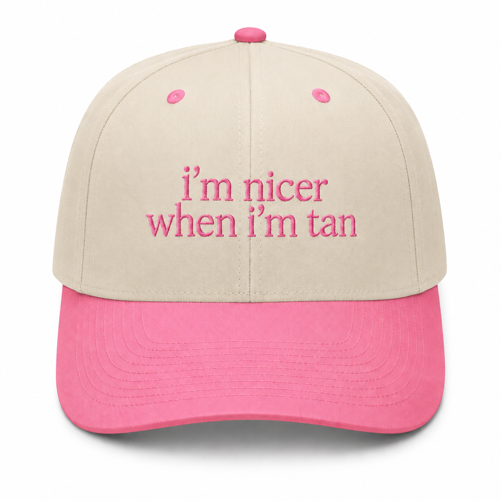 I'm Nicer When I'm Tan trucker hat in cream with pink brim and soft pink embroidered lettering, shown on a white background.
