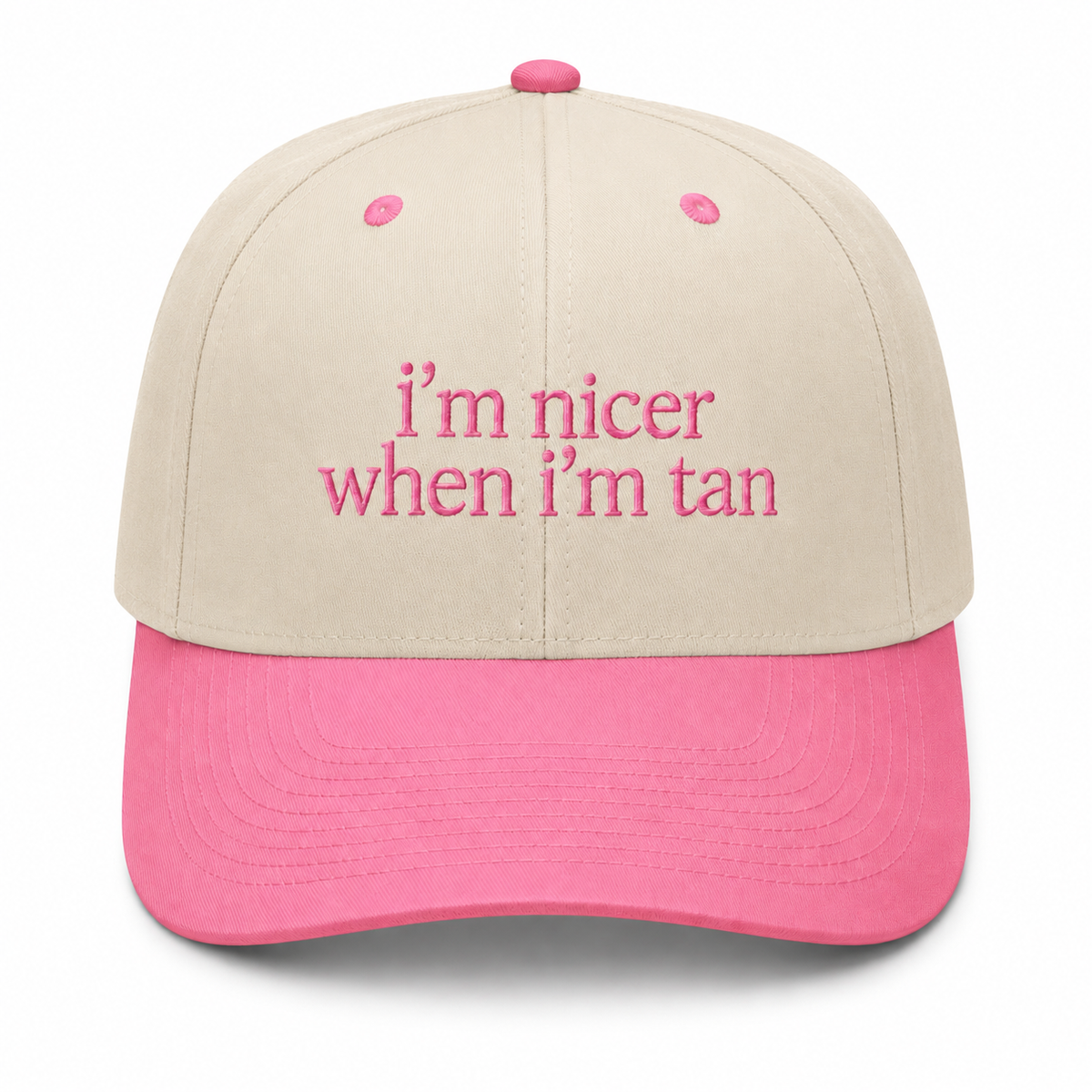 I'm Nicer When I'm Tan trucker hat in cream with pink brim and soft pink embroidered lettering, shown on a white background.

