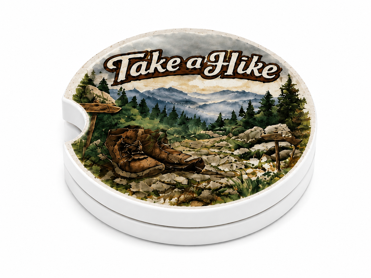 Take a Hike ceramic car coasters stacked showing thickness and finger notch cutout, watercolor mountain trail with hiking boots and pine trees design, set of 2
