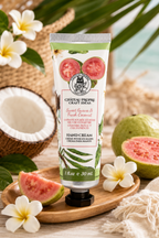 A tube of Château Propre Craft Ideas Sweet Guava & Fresh Coconut Hand Cream styled on a wooden tray with guava slices, white plumeria flowers, a woven basket, and tropical leaves in the background.
