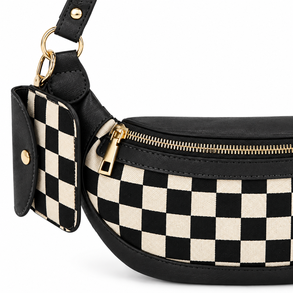Close-up of Duo Checkered Crossbody Bag in Black showing gold zipper pull detail along top edge, coordinating black and cream checkered mini wallet clipped to strap with gold carabiner and gold D-ring hardware, and black vegan leather trim with stitching detail on white background
