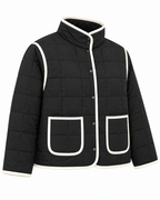 Black Quilted Contrast Trim Jacket three-quarter angle view showing black grid quilting, cream contrast trim along edges and collar, gunmetal snap buttons, and two cream-trimmed patch pockets on white background

