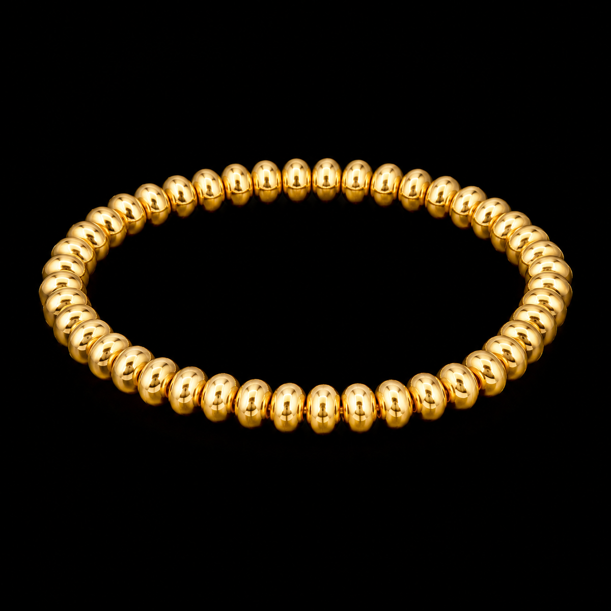 Gold beaded stretch bracelet with rondelle-style beads shown at an angle on black reflective surface
