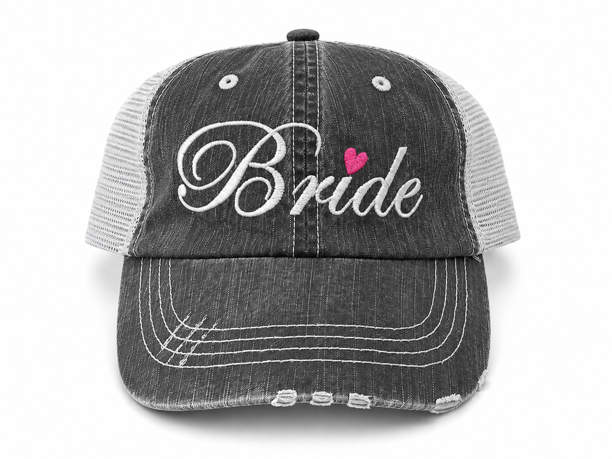 Bride distressed charcoal trucker hat with white script embroidery and pink heart detail, front view
