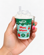 Apple Christmas Tree mini wipes cup held in one hand to show its compact size, decorative clear lid, and dangling apple charm
