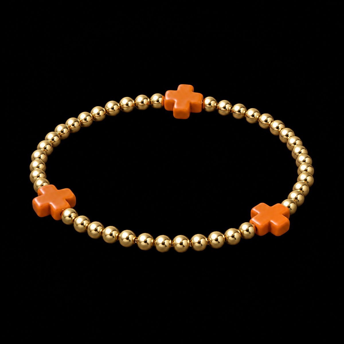 Gold ball bead stretch bracelet with orange cross accents shown at an angle on black reflective surface
